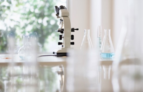 Microscope and beakers in laboratory