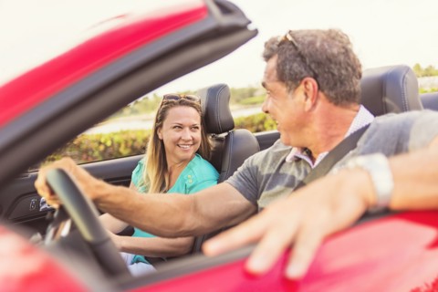 Caucasian couple driving convertible