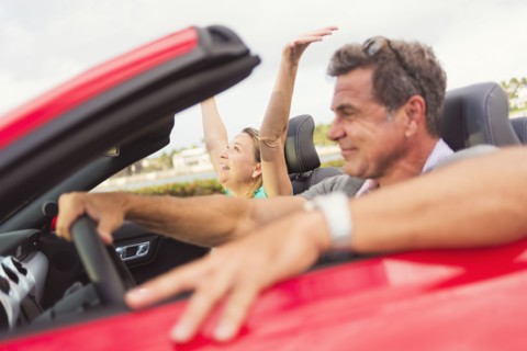 Caucasian couple driving convertible