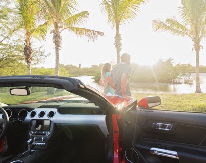 Caucasian couple walking near convertible