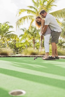 Caucasian couple playing miniature golf