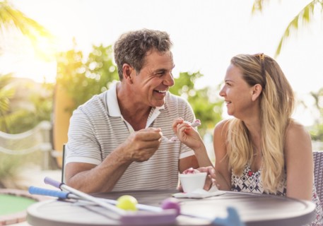 Caucasian couple eating ice cream at outdoor table