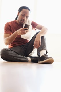 Black man using cell phone on floor