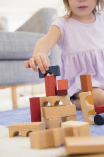 Caucasian girl playing with wooden blocks