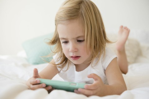 Caucasian girl using cell phone on bed