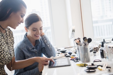 Makeup artist using digital tablet with client