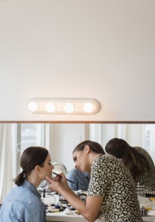 Woman having makeup applied by stylist