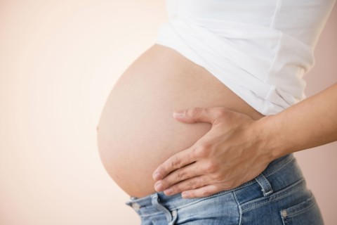 Pregnant Caucasian woman holding her belly