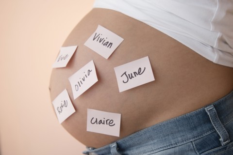 Pregnant Caucasian woman with name suggestions on belly