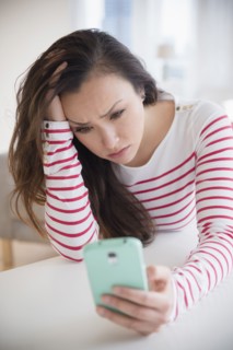 Stressed woman using cell phone