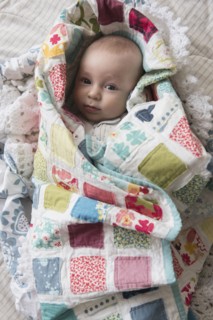 Caucasian baby wrapped in blanket