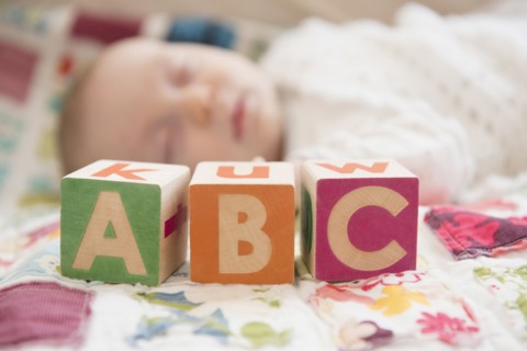 Caucasian baby napping near wooden blocks