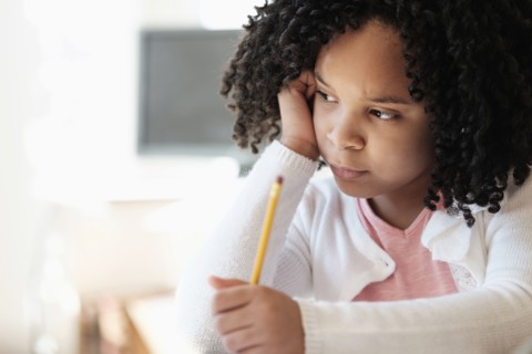 African American student writing in classroom
