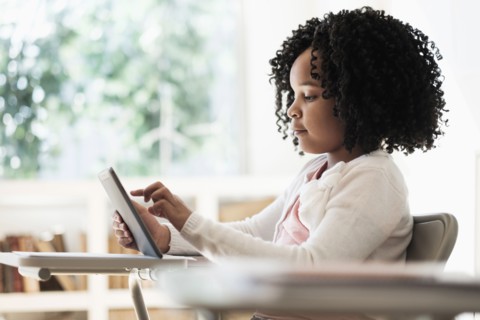 African American student using digital tablet in classroom