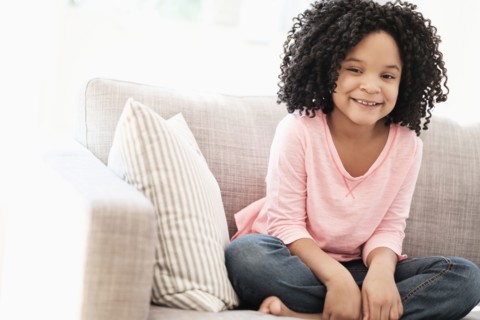 African American girl smiling on sofa
