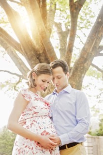 Pregnant Caucasian couple hugging outdoors