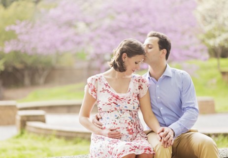 Pregnant Caucasian couple kissing outdoors