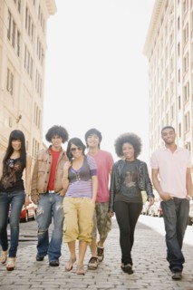 Multi-ethnic friends walking down urban sidewalk