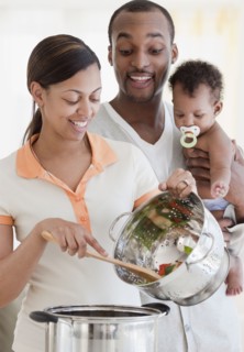 African couple and baby cooking