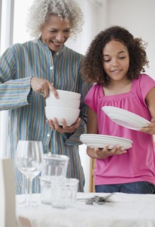 Grandmother and granddaughter setting table