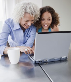 Grandmother and granddaughter using laptop