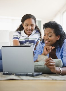 Mother and daughter using credit card online