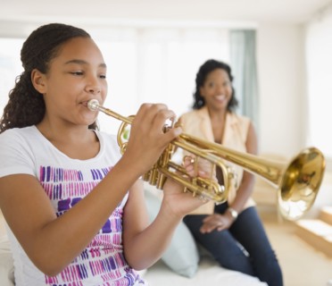 Mother watching daughter playing trumpet