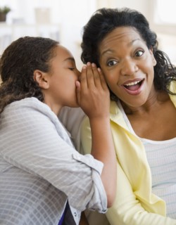 Daughter whispering secret to mother