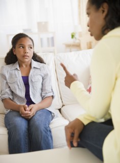 Mother lecturing daughter in living room
