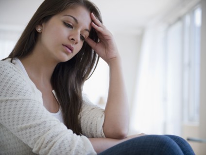 Disappointed Indian woman with head in hands