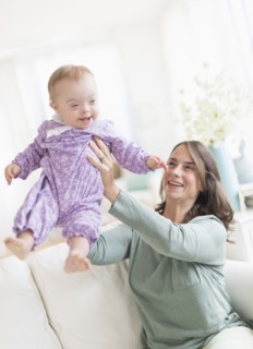 Caucasian mother playing with baby with Down Syndrome