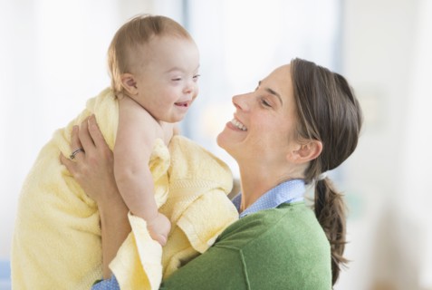 Caucasian mother toweling baby girl with Down Syndrome