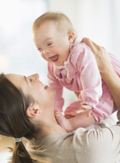 Caucasian mother playing with baby girl with Down Syndrome