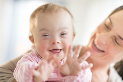 Caucasian mother playing with baby girl with Down Syndrome