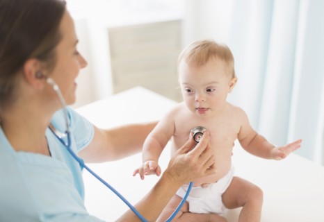 Caucasian doctor tending to baby girl with Down Syndrome