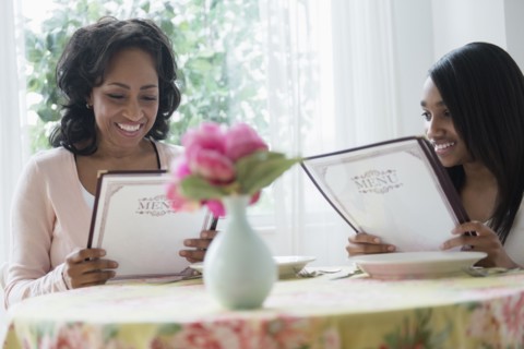 Mother and daughter reading menus in restaurant
