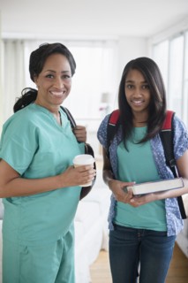 Smiling nurse and daughter leaving house in morning