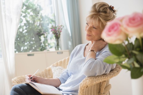 Older Caucasian woman writing in journal