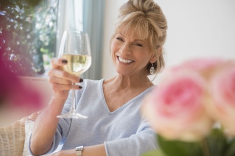 Older Caucasian woman drinking white wine