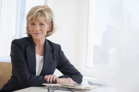 Smiling Caucasian businesswoman sitting at desk