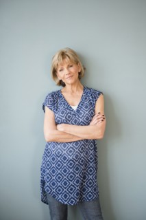 Confident older Caucasian woman standing at wall