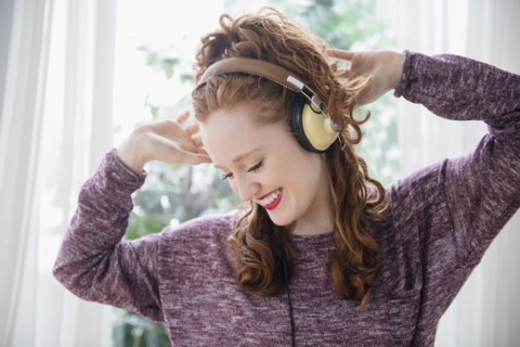 Caucasian woman listening to headphones and dancing