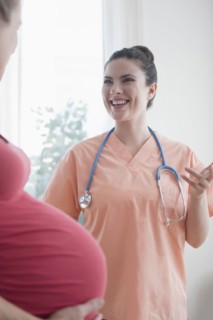Caucasian nurse consulting with expectant mother