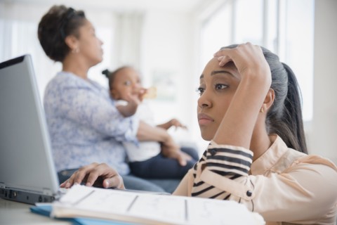 Stressed Black woman paying bills using laptop