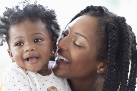 Close of  smiling Black woman and baby daughter