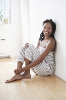 Smiling Black woman sitting on floor