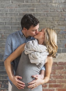 Caucasian man hugging and kissing expectant mother
