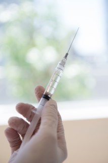 Hand holding syringe
