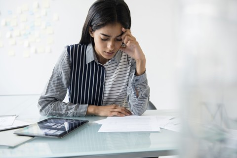 Indian businesswoman reading paperwork in office