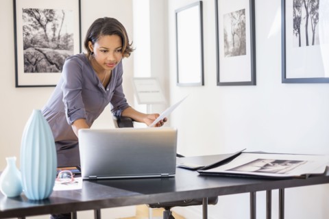 Black businesswoman using laptop in art gallery office